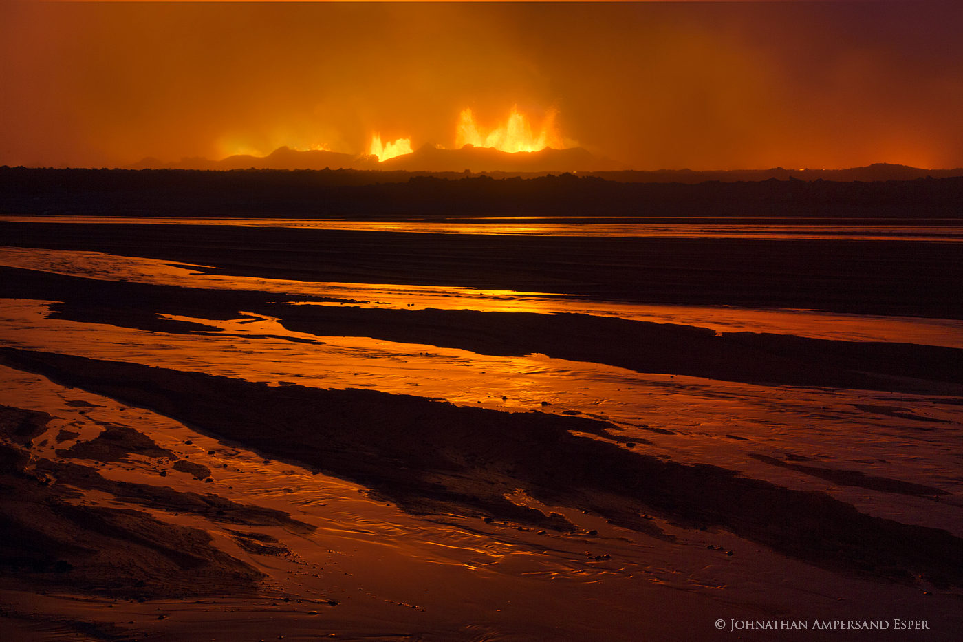 Holuhraun eruption red glow reflection in an intermittent stream, after sunset