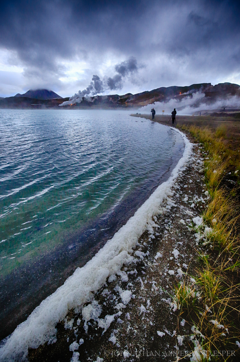 People walk along the shore of Lake Myvatn in northern Iceland in Autumn