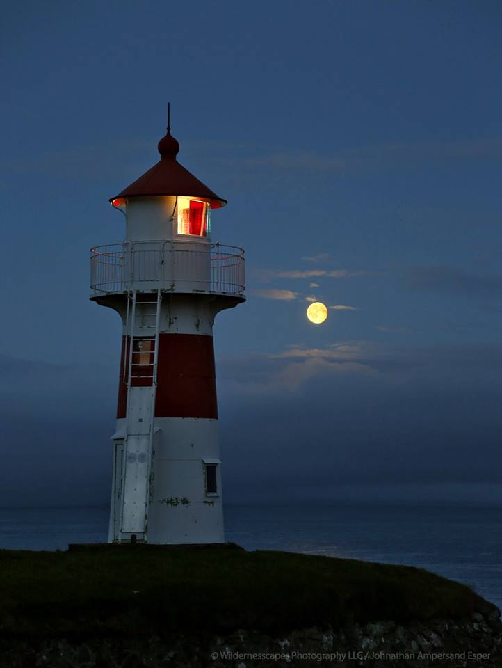 Torshavin harbour lighthouse and full rising moon above sea fog